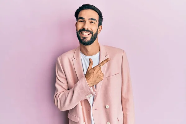顔を指差す笑顔でビジネスジャケットを纏った若いヒスパニック系の男が幸せそうな自然な表情で側に手と指を上げて — ストック写真