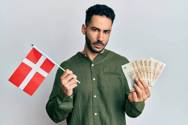Młody Latynos Trzymający Flagę Denmarkową Banknoty Koronowe Przygnębiony Zaniepokojony Strachem — Zdjęcie stockowe