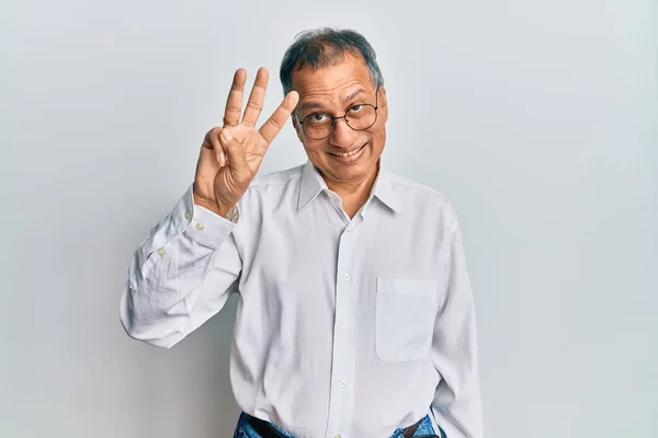 印度中年男子身穿休闲装 戴着眼镜 三指一指 面带微笑 自信而快乐 — 图库照片