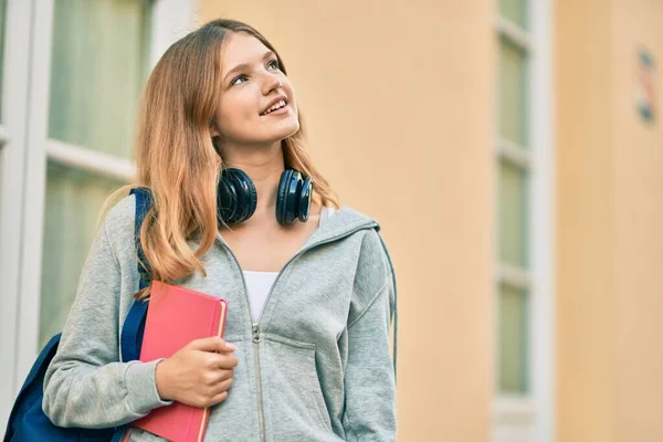 Όμορφη Καυκάσιος Έφηβος Φοιτητής Χρησιμοποιώντας Ακουστικά Κρατώντας Βιβλίο Στην Πόλη — Φωτογραφία Αρχείου