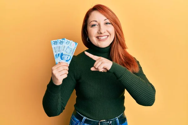 Hermosa Pelirroja Sosteniendo Billetes Pesos Mexicanos Sonriendo Feliz Señalando Con —  Fotos de Stock