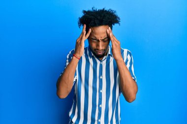 Sakallı, sıradan çizgili tişörtlü, başı ağrıyan genç Afrikalı Amerikalı bir adam. migren ağrısı. 