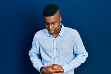 Afro-Amerikalı genç bir adam, hazımsızlık, acı verici bir hastalık ve midesi üzerine gündelik giysiler giyiyor. Ağrı kavramı. 