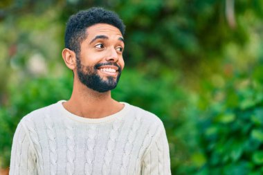 Genç Afrikalı Amerikalı adam parkta mutlu bir şekilde dikiliyor..