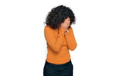 Ağlarken yüzünü ellerle kapatan, günlük kıyafetler giyen genç İspanyol kadın. depresyon kavramı. 