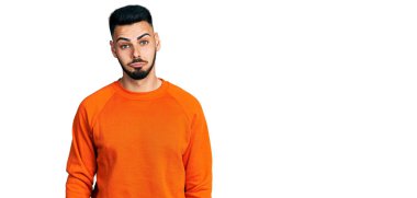 Sakallı, günlük turuncu kazak giyen, kederli, sinirli ve korkmuş bir İspanyol. hüzünlü ifade. 