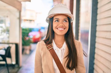 Genç, latin mimar kız gülümseyerek şehirde mutlu mesut duruyor..