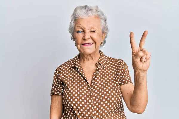 Starsza Siwowłosa Kobieta Luźnych Ciuchach Uśmiechnięta Szczęśliwą Twarzą Mrugająca Kamery — Zdjęcie stockowe