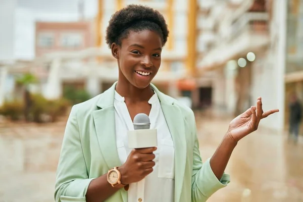 年轻的非洲裔美国女记者在城市使用话筒 — 图库照片