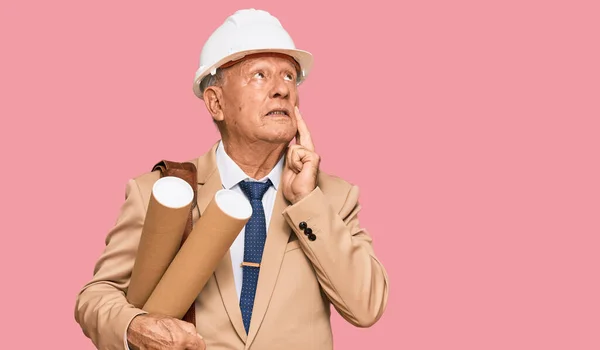 Senior Kaukasier Man Bär Skyddshjälm Hålla Ritningar Allvarliga Ansikte Tänka — Stockfoto