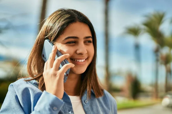 若いですラテン語の女の子笑顔幸せな話上のスマートフォンで街 — ストック写真