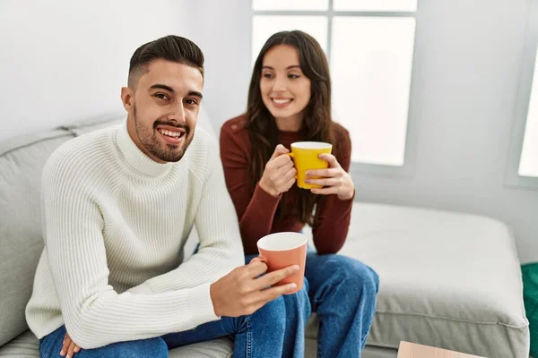 Young Hispanic Couple Drinking Coffee Sitting Sofa Home — Stock Photo, Image
