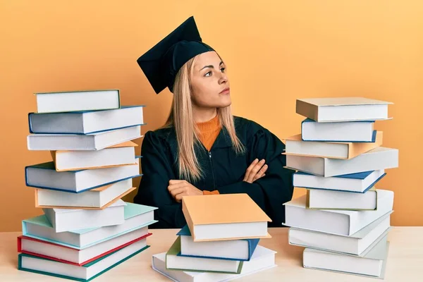 Junge Kaukasische Frau Abschlusszeremoniengewand Sitzt Auf Dem Tisch Und Blickt — Stockfoto