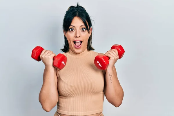 Mujer Hispana Joven Usando Ropa Deportiva Usando Pesas Asustada Sorprendida —  Fotos de Stock