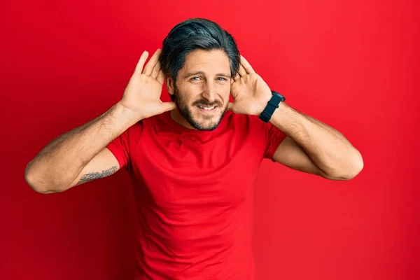 Young Hispanic Man Wearing Casual Red Shirt Trying Hear Both — Stock Photo, Image