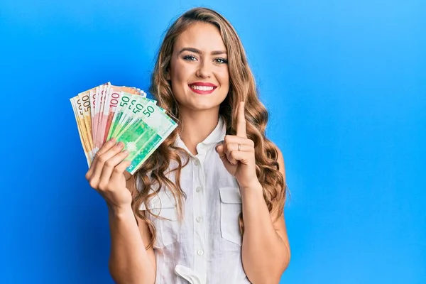 Joven Chica Rubia Sosteniendo Billetes Noruegos Sonriendo Con Una Idea — Foto de Stock