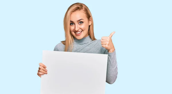 Hermosa Mujer Caucásica Sosteniendo Banner Vacío Blanco Sonriendo Feliz Positivo —  Fotos de Stock