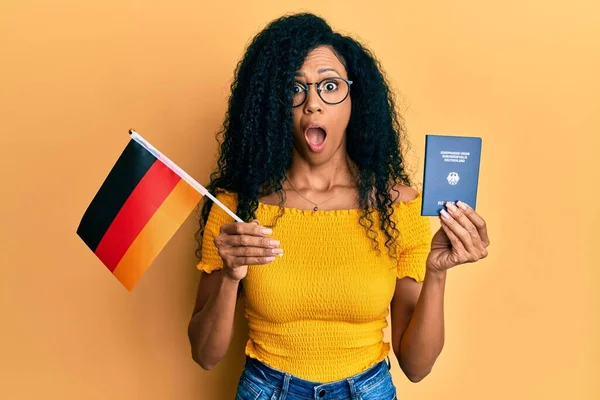 Mujer Afroamericana Mediana Edad Con Bandera Alemania Pasaporte Asustada Conmocionada —  Fotos de Stock
