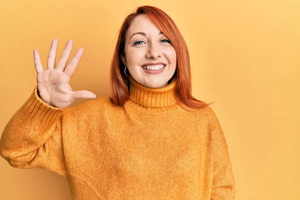 아름다운 여자가 스웨터를 위에서 자신감 행복하게 웃으면서 손가락으로 손가락을 가리키는 — 스톡 사진