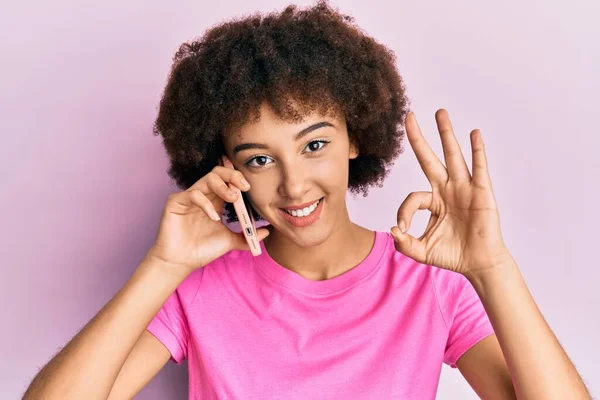 Młoda Latynoska Dziewczyna Rozmawia Smartfonie Robi Znak Palcami Uśmiecha Się — Zdjęcie stockowe