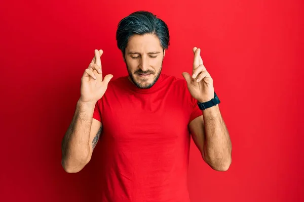 Giovane Uomo Ispanico Indossa Casual Shirt Rossa Gesticolando Dito Incrociato — Foto Stock