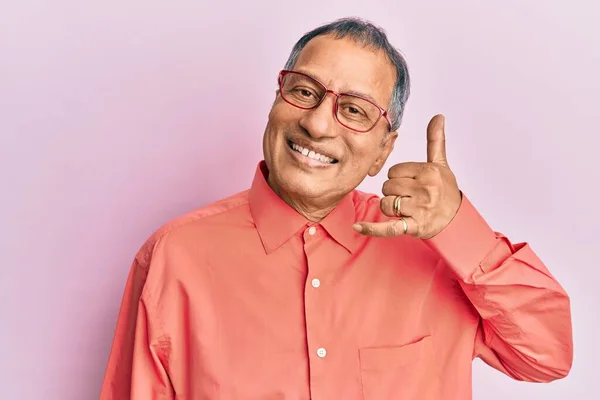 中年印度男人 穿着休闲装 戴着眼镜 微笑着用手和手指做着电话手势 就像在电话里说话一样 交流概念 — 图库照片