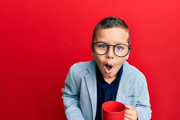 Ragazzino Con Gli Occhiali Che Beve Una Tazza Rossa Spaventato — Foto Stock