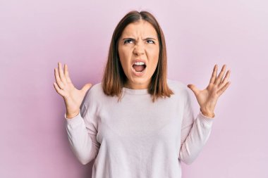 Genç ve güzel bir kadın gündelik kıyafetler giyip deli gibi bağırıyor ve agresif bir ifade ve kollarla bağırıyor. hüsran kavramı. 