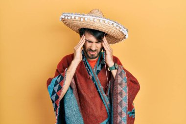 Meksika şapkası tutan genç bir İspanyol. Stres yüzünden baş ağrısı çekiyor. migren ağrısı. 
