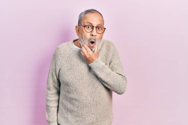 Sakallı, sıradan süveter giyen ve gözlüklü yakışıklı bir adam. İnançsızlıktan, şaşkınlıktan ve elleri çenesinde şaşkınlıktan büyülenmiş gibi görünüyor. 