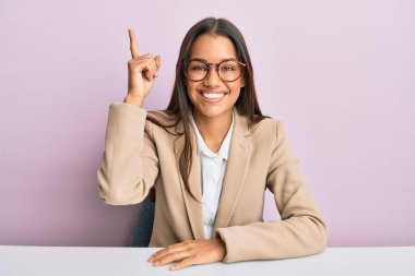 Ofiste çalışan güzel İspanyol bir kadın başarılı bir fikri işaret ediyor. Heyecanlı ve mutlu. Bir numara.. 