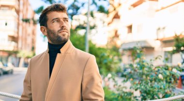 Dışarıda şık bir ceket giyen yakışıklı bir iş adamı.