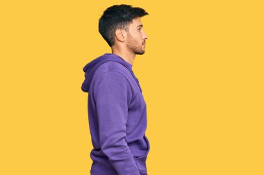 Tişört giyen genç yakışıklı bir adam. Taraf arıyor, rahat profil pozu veriyor. Kendine güvenen bir gülümseme takınıyor.. 