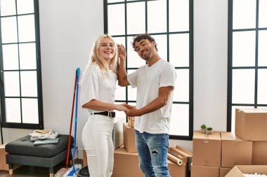 Genç ve güzel bir çift yeni evinde mutlu bir şekilde dans ediyor.