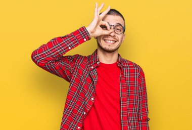 İspanyol genç adam günlük kıyafetler giyiyor. El hareketleriyle gülümsüyor, gözleriyle mutlu yüzlere bakıyor.. 