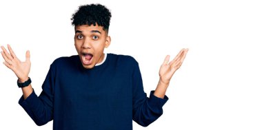 Genç afro-amerikan adam gündelik giysiler giyip çılgınlığı kutluyor ve başarıya hayret ediyor kolları açık ve gözleri açık heyecanla bağırıyor. Kazanan konsept 