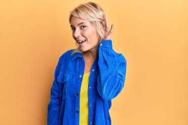 Sıradan kıyafetler giyen, el pençe divan gülümseyen, dedikodu ya da dedikoduları dinleyen genç sarışın kız. Sağırlık kavramı. 