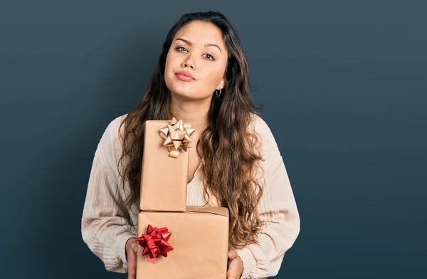 Young Hispanic Girl Holding Gifts Skeptic Nervous Frowning Upset Because — Stock Photo, Image