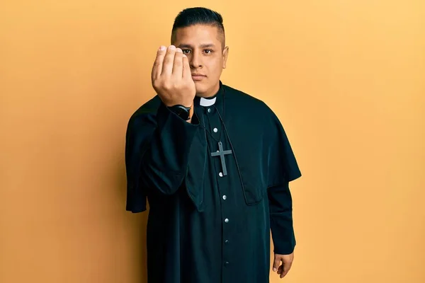 Genç Latin Rahip Sarı Arka Planda Duruyor Talyan Jestleri Yapıyor — Stok fotoğraf