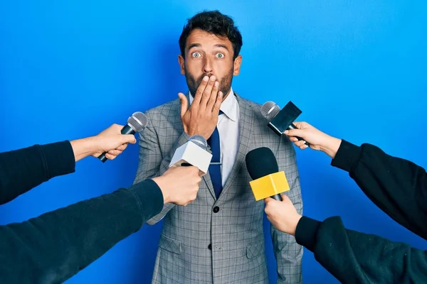 Przystojny Facet Brodą Przesłuchany Przez Reporterów Trzymających Mikrofon Zakrywający Usta — Zdjęcie stockowe