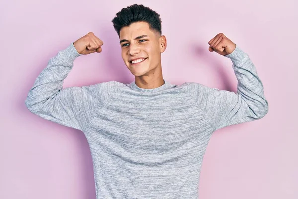 Jovem Hispânico Vestindo Roupas Casuais Mostrando Músculos Dos Braços Sorrindo — Fotografia de Stock