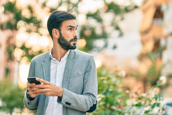 Jovem Empresário Hispânico Com Expressão Séria Usando Smartphone Cidade — Fotografia de Stock