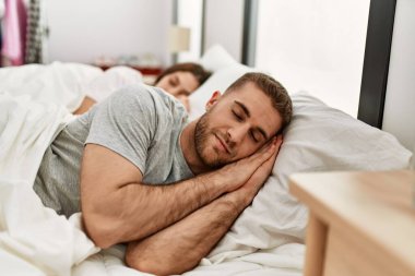 Kafkasyalı genç bir çift evde yatakta uyuyor..