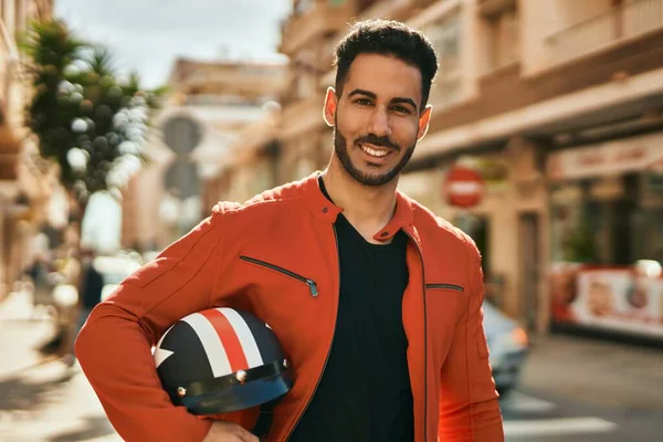 Νεαρός Ισπανόφωνος Χαμογελώντας Χαρούμενος Κρατώντας Κράνος Μοτοσικλέτας Στην Πόλη — Φωτογραφία Αρχείου