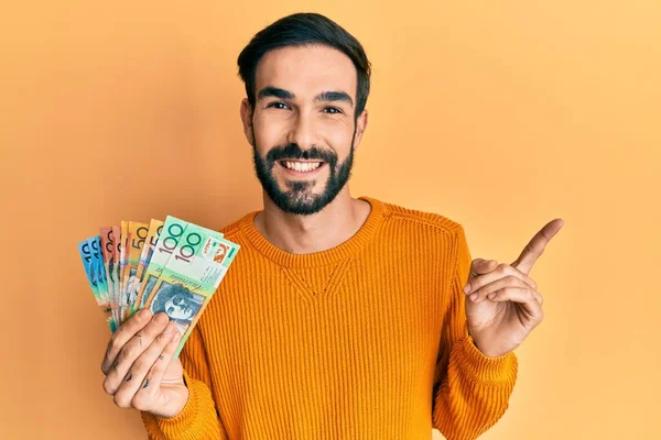 Joven Hispano Sosteniendo Dólares Australianos Sonriendo Feliz Señalando Con Mano — Foto de Stock