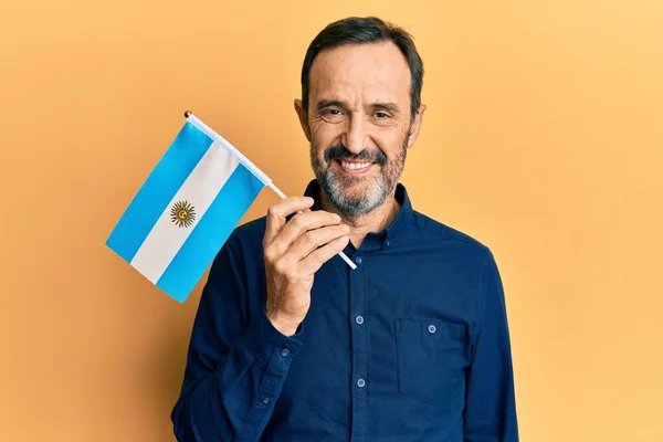 Medelålders Latinamerikan Man Håller Argentina Flagga Ser Positiv Och Glad — Stockfoto