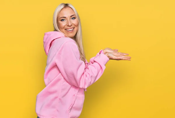 Ung Blond Kvinna Bär Casual Sweatshirt Pekar Sidan Med Händerna — Stockfoto