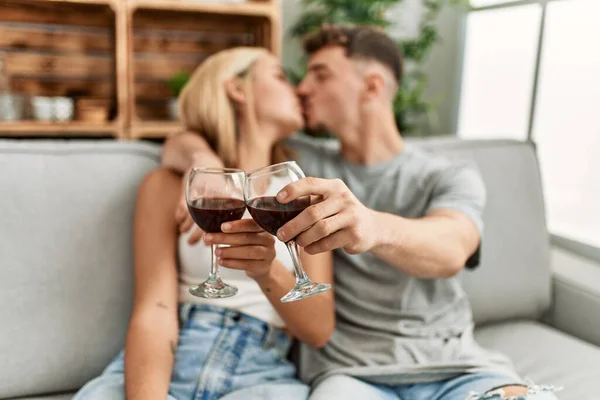 Joven Pareja Caucásica Besando Brindando Con Vino Tinto Casa — Foto de Stock