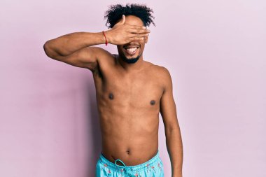 Sakallı, mayolu, gülümseyen ve gülen genç, Afro-Amerikan bir adam. Şaşırtmak için gözlerini kapatıyor. kör kavram. 