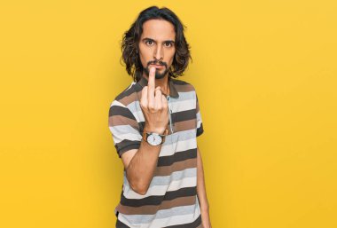 Young hispanic man wearing casual clothes showing middle finger, impolite and rude fuck off expression 